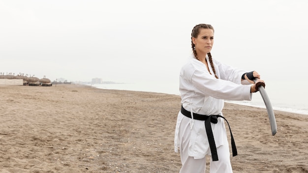 Photo gratuite jeune femme en costume de karaté en plein air