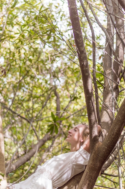 Jeune femme couchée sur un arbre et repos