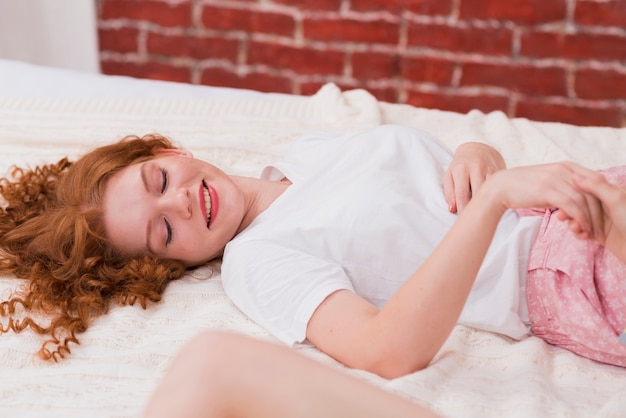 Jeune femme couchée dans son lit