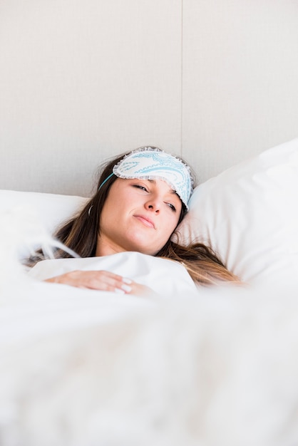 Jeune femme, coucher lit, à, couverture, porter, masque pour ses yeux, front