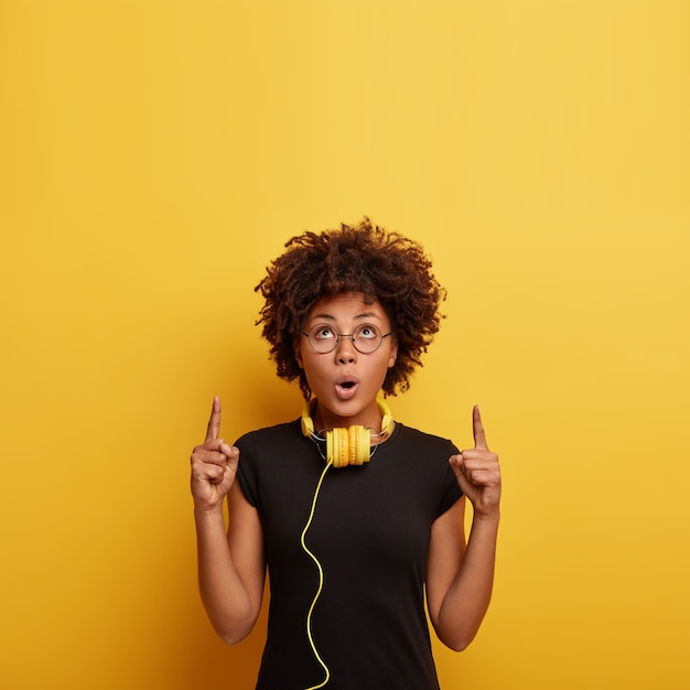 Photo gratuite jeune femme avec coupe de cheveux afro avec un casque jaune