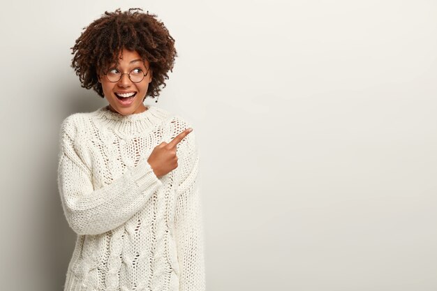 Jeune femme avec coupe de cheveux afro portant un pull blanc