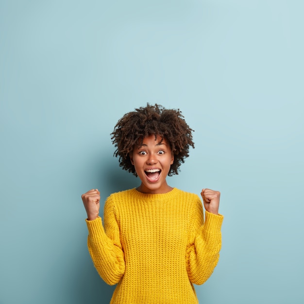 Photo gratuite jeune femme avec coupe de cheveux afro portant un pull jaune