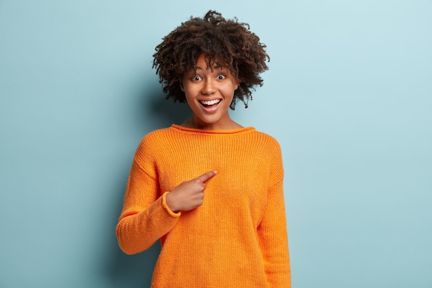 Photo gratuite jeune femme avec coupe de cheveux afro portant un pull orange
