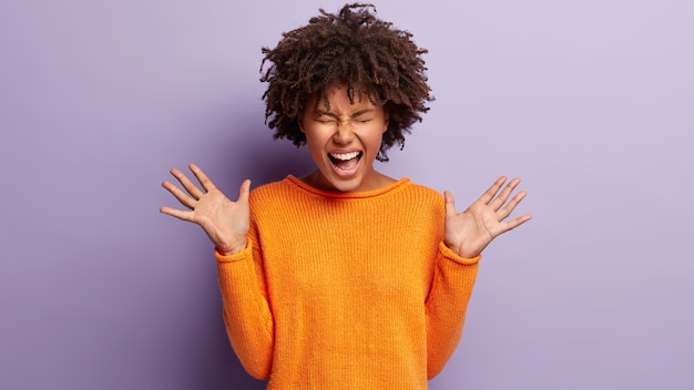 Photo gratuite jeune femme avec coupe de cheveux afro portant un pull orange