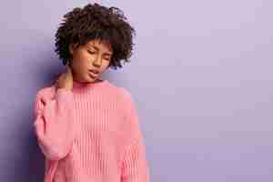 Photo gratuite jeune femme avec coupe de cheveux afro portant un pull rose