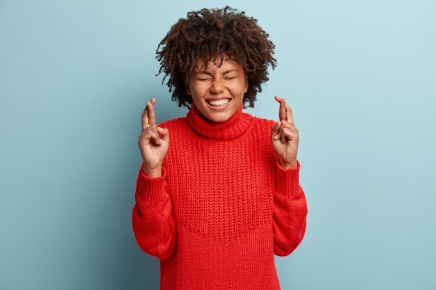 Jeune femme avec coupe de cheveux afro portant un pull rouge