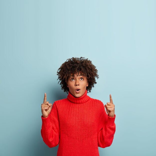 Jeune femme avec coupe de cheveux afro portant un pull rouge