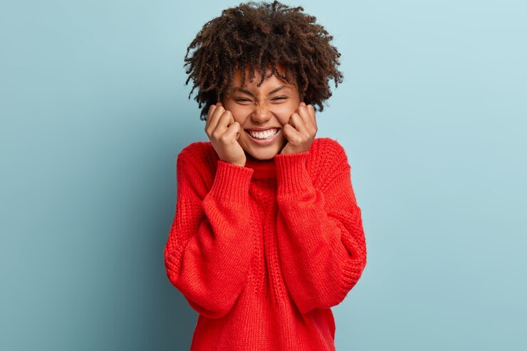 Photo gratuit jeune femme avec coupe de cheveux afro portant un pull rouge