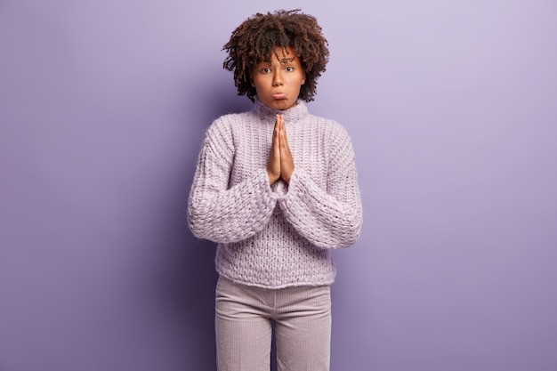 Jeune femme avec coupe de cheveux afro portant un pull violet