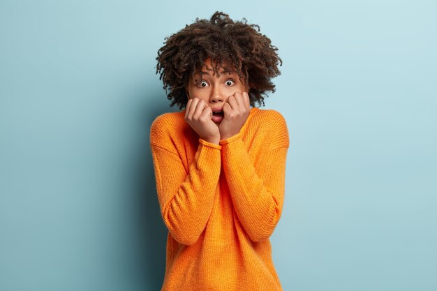 Jeune femme avec coupe de cheveux afro portant un pull