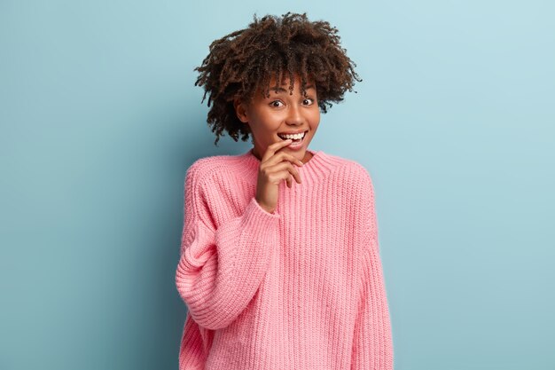 Jeune femme avec coupe de cheveux afro portant un pull