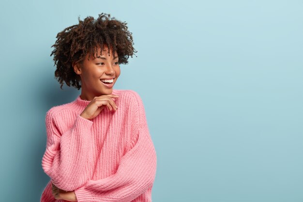 Jeune femme avec coupe de cheveux afro portant un pull