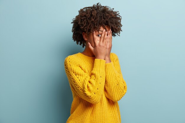 Jeune femme avec coupe de cheveux afro portant un pull