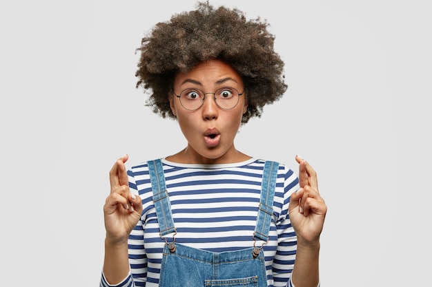 Jeune femme avec coupe de cheveux afro portant une salopette en denim