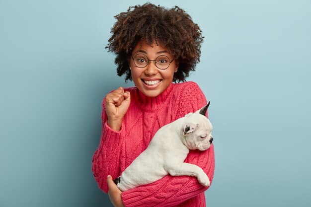 Jeune femme avec coupe de cheveux afro tenant chiot