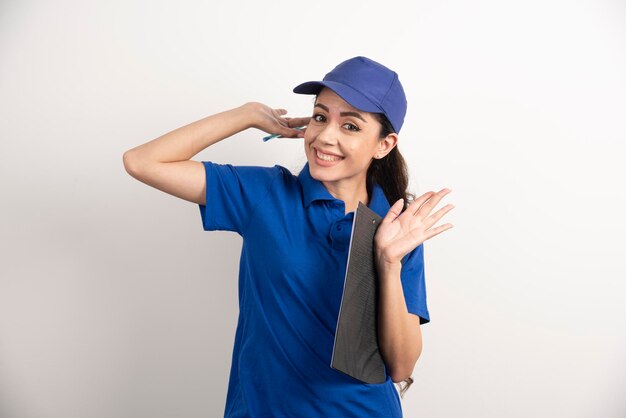 Jeune femme coursier en gommages bleus tenant un presse-papiers. photo de haute qualité