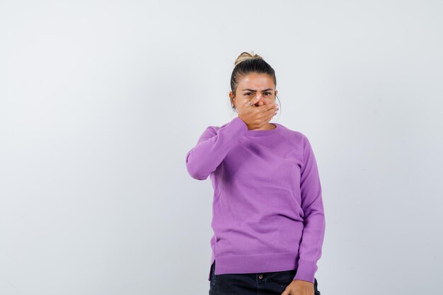 Jeune femme couvrant la bouche avec la main et semblant choquée