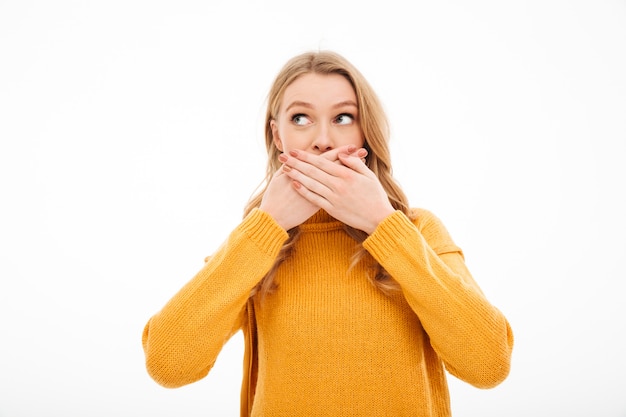 Jeune femme couvrant la bouche avec les mains.