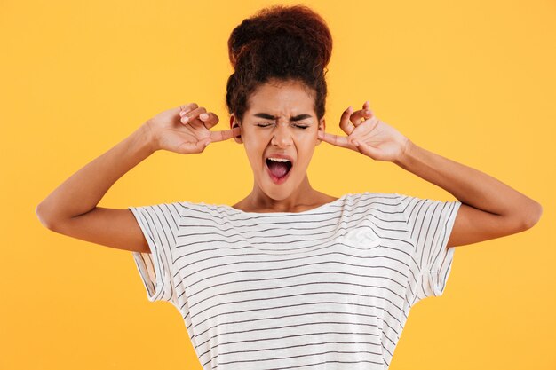 Jeune femme couvrant ses oreilles pour ne pas écouter