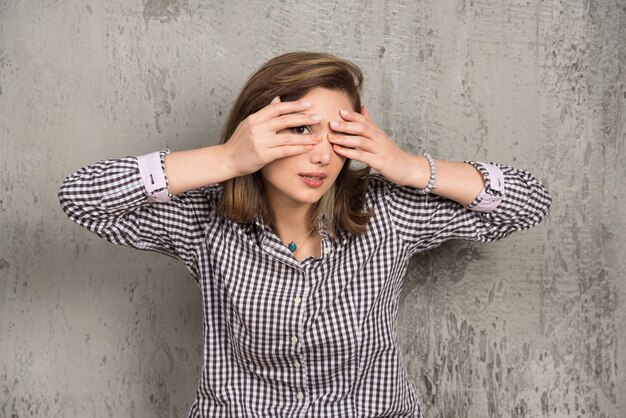 Une jeune femme couvrant ses yeux avec ses mains avec une belle manucure