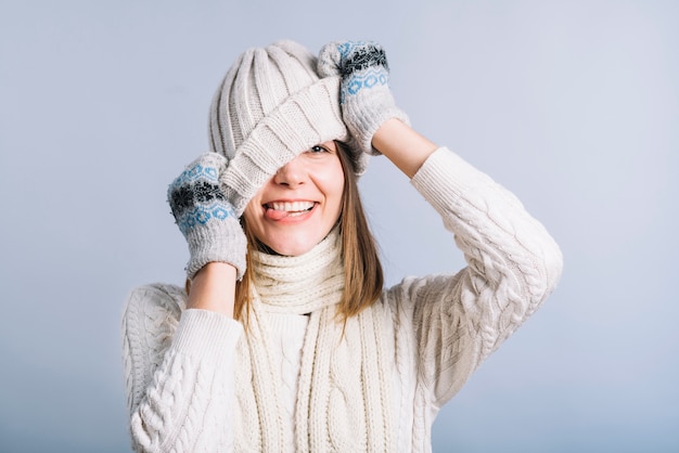 Photo gratuite jeune femme couvrant le visage avec un bonnet clair