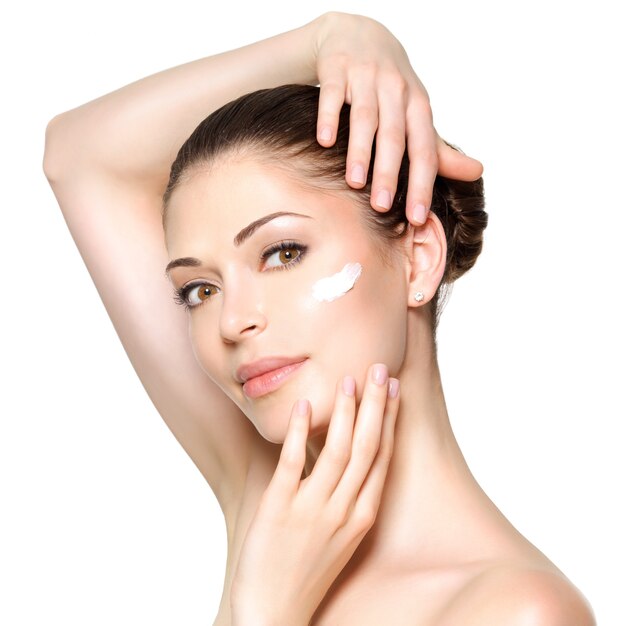 Jeune femme avec de la crème cosmétique sur un visage frais et propre. Concept de soins de la peau