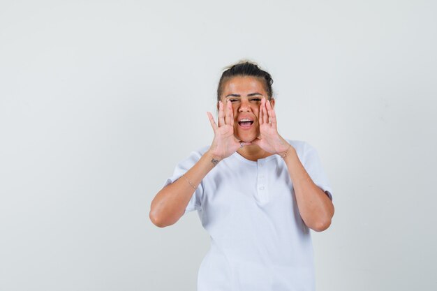 Jeune femme criant ou annonçant quelque chose en t-shirt