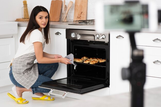 Jeune femme cuisine pour une vidéo