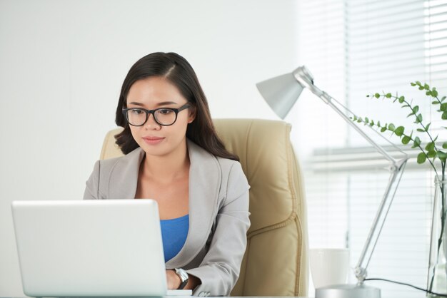 Jeune femme dame rédiger un document sur ordinateur portable au bureau