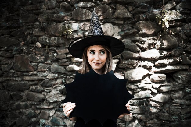 Jeune femme, dans, chapeau sorcière, tenue, décoration halloween, et, regarder loin