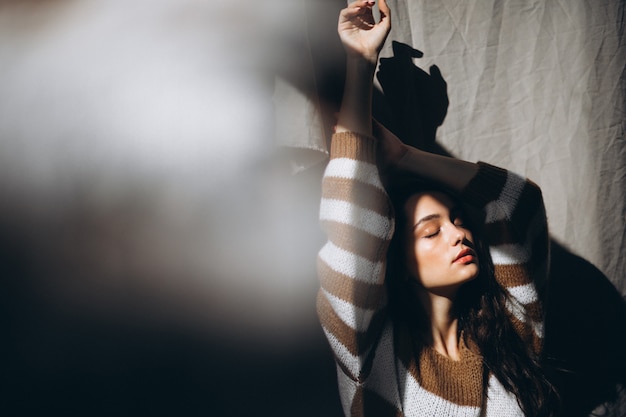 Jeune femme dans un pull chaud assis sur le sol