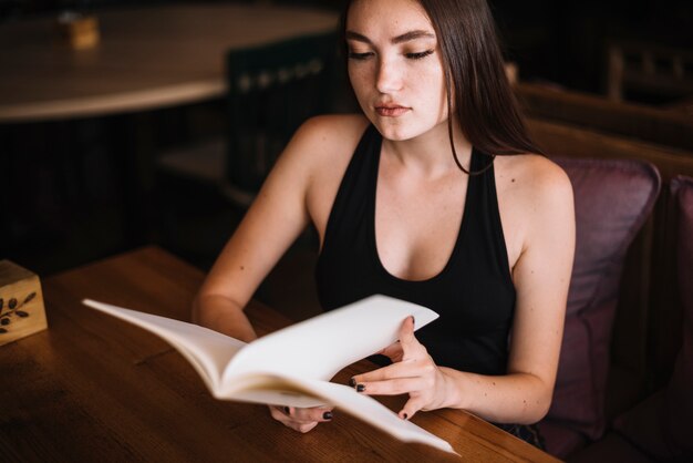 Une jeune femme dans un restaurant avec le menu en mains