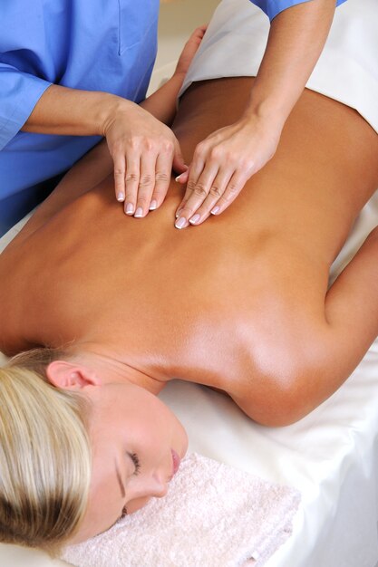 Jeune femme dans un salon de beauté en prenant un massage pour son dos