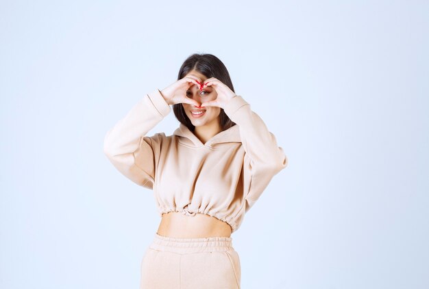 Jeune femme dans un sweat à capuche rose donnant des poses charmantes et chaleureuses