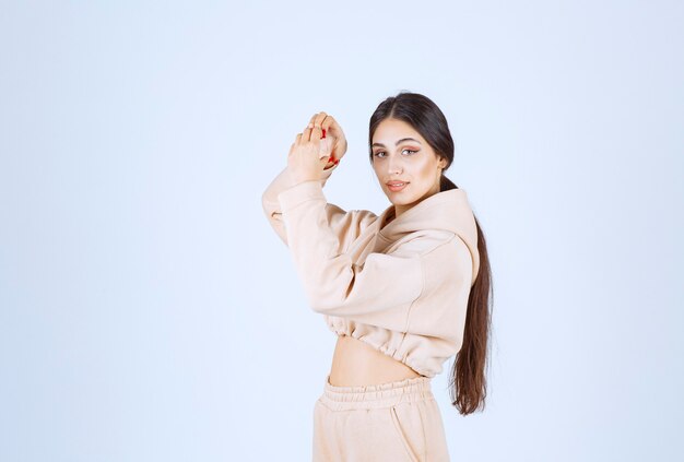 Jeune femme dans un sweat à capuche rose donnant des poses charmantes et chaleureuses