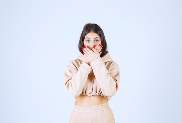 Jeune femme dans un sweat à capuche rose effrayé et effrayé