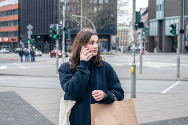 Une jeune femme dans la ville dans la rue avec un concept de forfait shopping