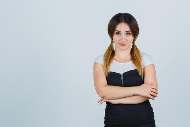 Jeune femme debout les bras croisés et à la confiance