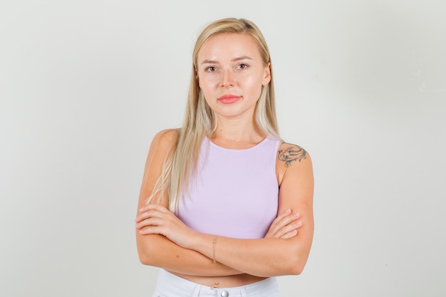 Jeune femme debout avec les bras croisés en maillot, mini jupe et à la confiance.