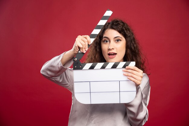 Jeune femme debout avec clap.