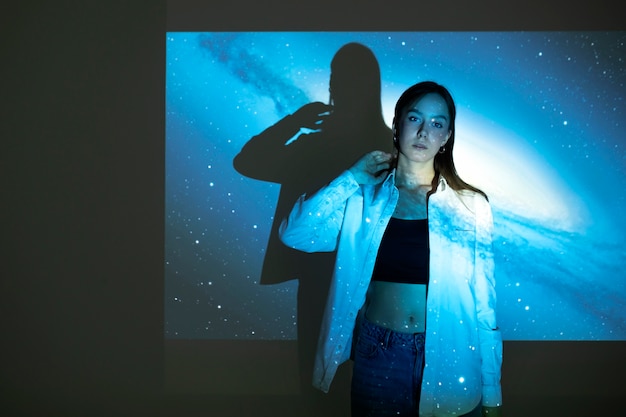 Jeune femme debout dans la projection de texture de l'univers