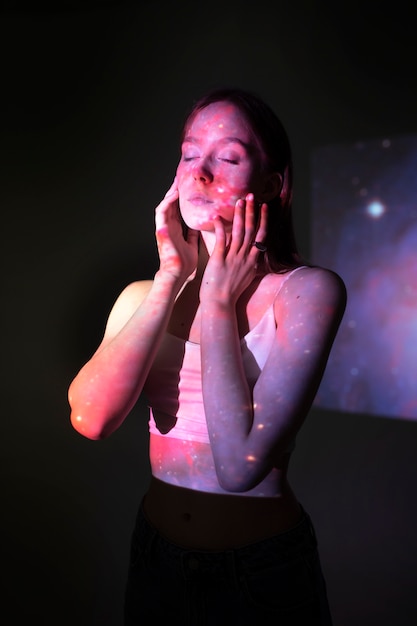 Photo gratuite jeune femme debout dans la projection de texture de l'univers