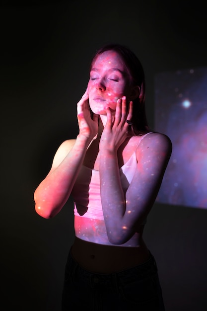 Jeune femme debout dans la projection de texture de l'univers