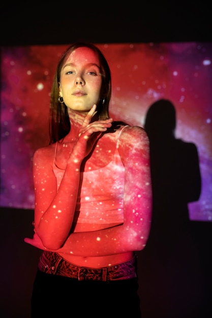 Jeune femme debout dans la projection de texture de l'univers