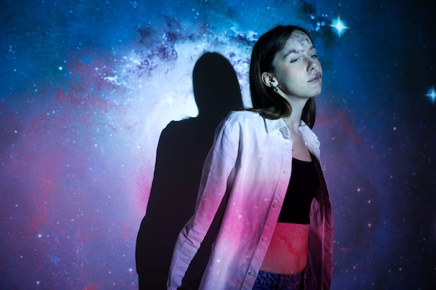 Jeune femme debout dans la projection de texture de l'univers