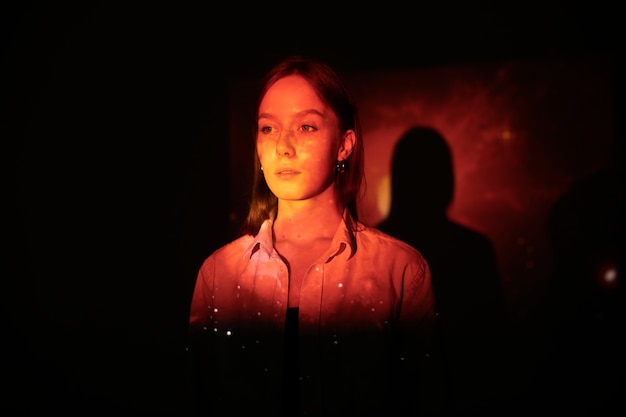 Jeune femme debout dans la projection de texture de l'univers