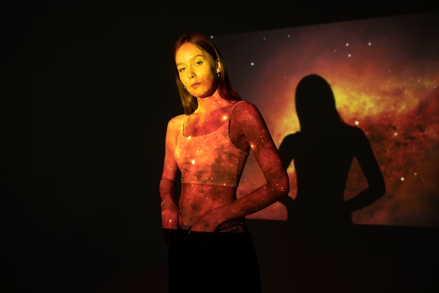 Jeune femme debout dans la projection de texture de l'univers