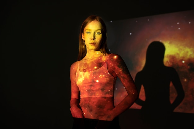 Jeune femme debout dans la projection de texture de l'univers