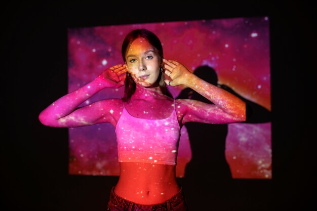 Jeune femme debout dans la projection de texture de l'univers